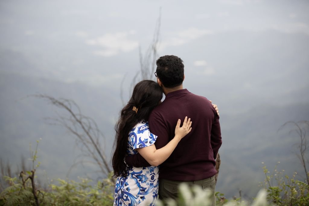 A couple embracing while enjoying a serene view from a mountainside, exuding love and tranquility.